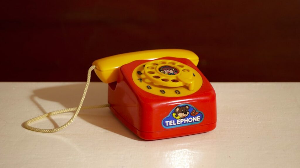 A bright red and yellow toy telephone.