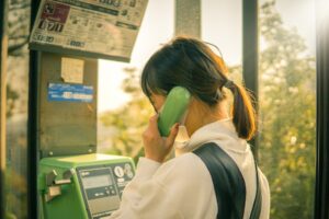 woman in white long sleeve shirt using green smartphone