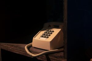 a telephone sitting on top of a wooden shelf
