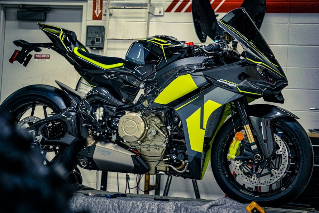 A black and yellow sport motorcycle on a lift.
