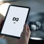 Hands holding a tablet displaying ai logo