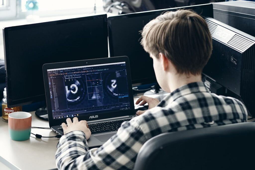 man in black and white plaid dress shirt using black laptop computer