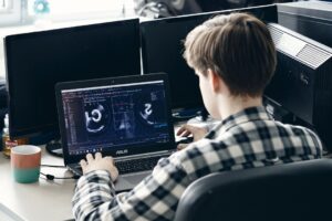 man in black and white plaid dress shirt using black laptop computer
