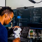 a man is looking through a microscope at a computer
